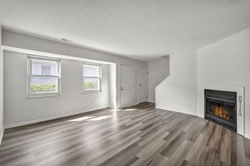 A room with a fireplace and wood flooring.